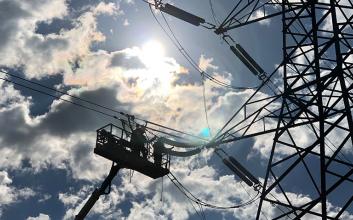 Staff in an EWP working on insulators on a tower