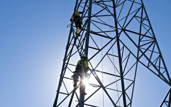 Workers up transmission tower