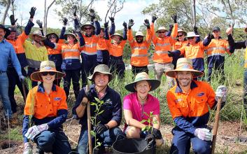 Volunteers, business reps and local member planting trees
