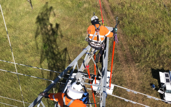 Workers at top of transmission tower