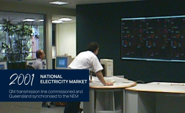 Two Powerlink employees leaning over a desk looking at a control screen