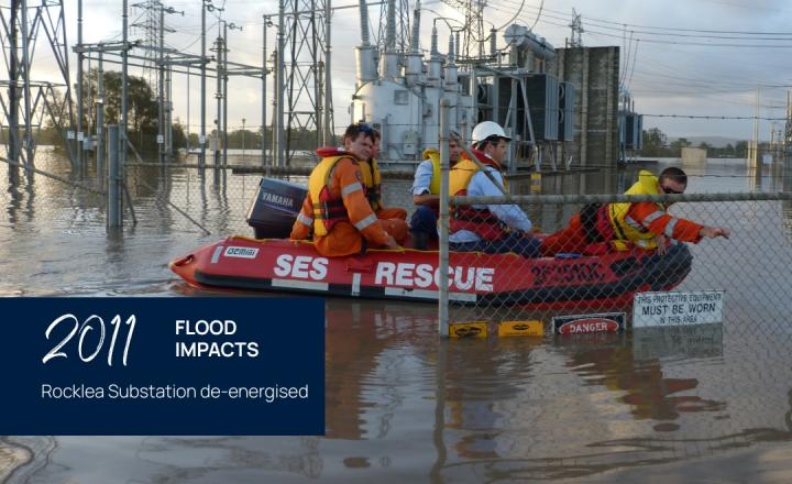 Workers in an emergency services rescue boat drive around a flooded substation