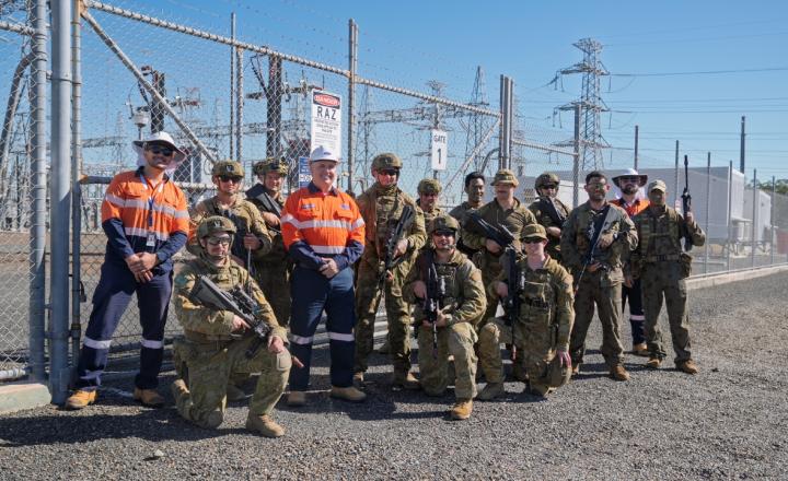 group of people in uniform in front of substation
