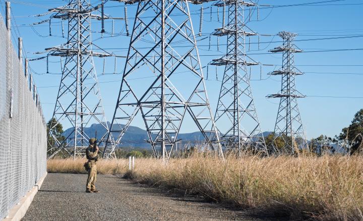 person outside substation under towers 