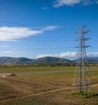 Two transmission towers in front of a mountain